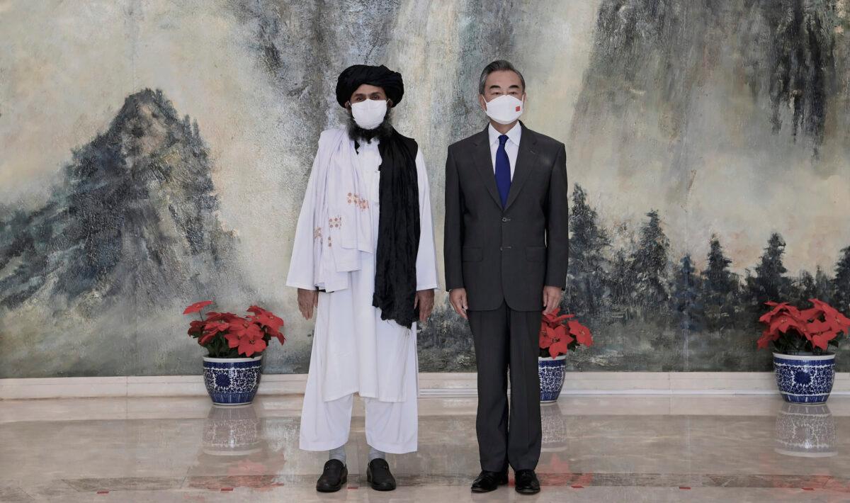 Taliban co-founder Mullah Abdul Ghani Baradar (L) and Chinese Foreign Minister Wang Yi pose for a photo during their meeting in Tianjin, China, on July 28, 2021. (Li Ran/Xinhua via AP)
