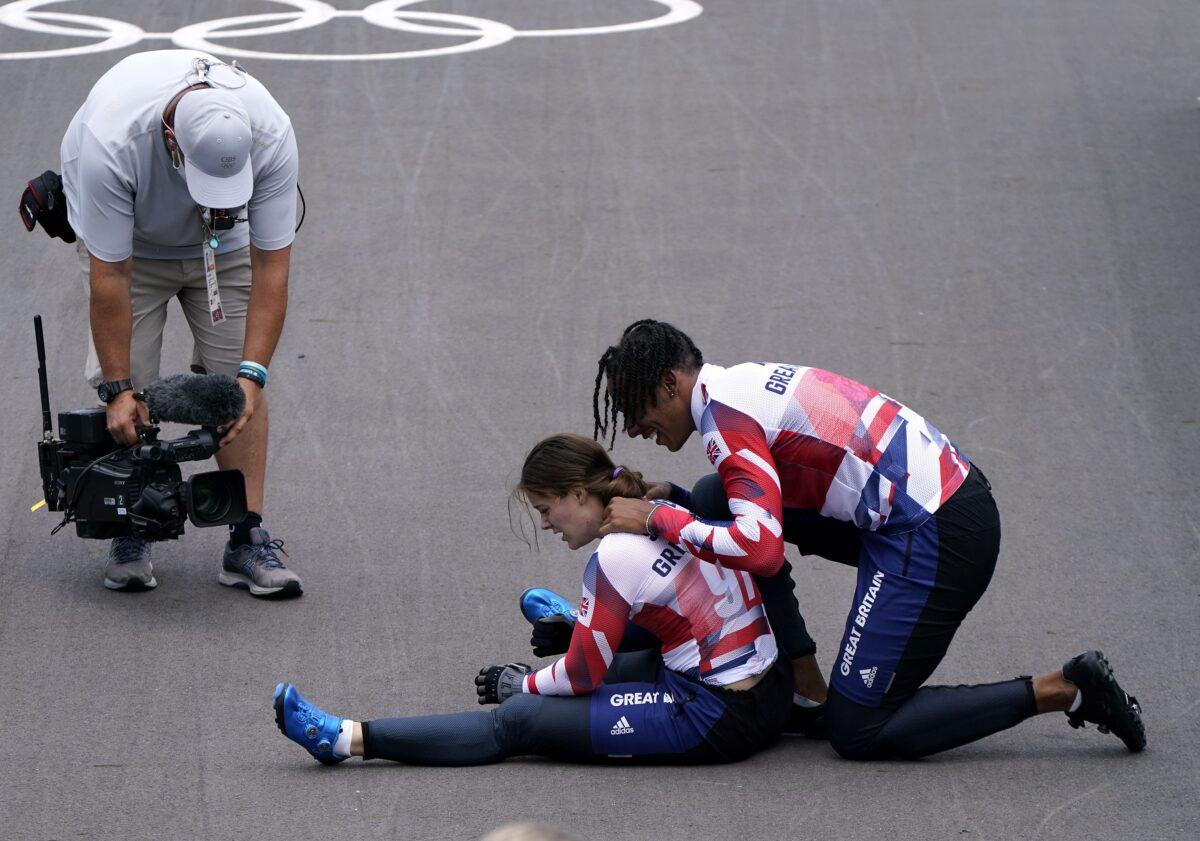 Kye Whyte with Beth Shriever after she collapsed on the track in relief after her gold medal ride at Tokyo 2020 Olympic Games, Tokyo, Japan, on July 30, 2021. (Danny Lawson/PA)