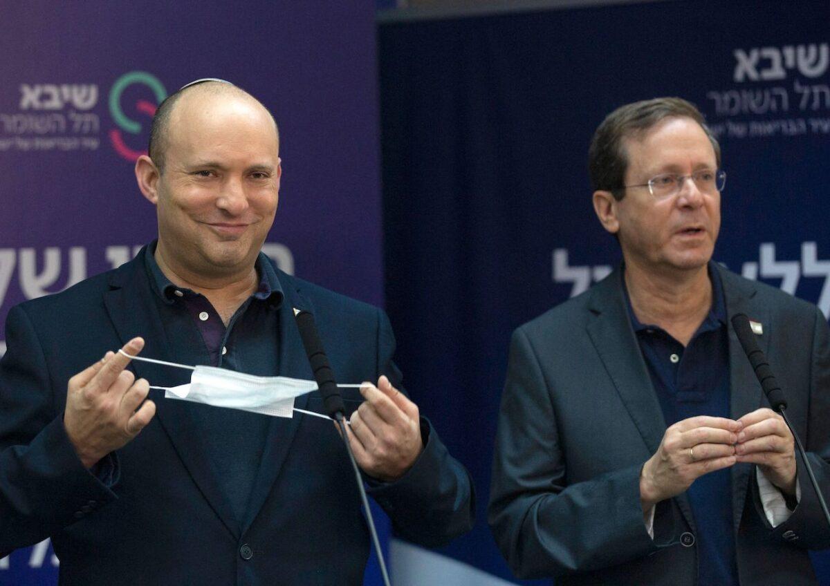 Israeli President Isaac Herzog (R) and Prime Minister Naftali Bennett speak to the media after the former received a third dose of the Pfizer/BioNTech Covid-19 vaccine at Sheba Medical Center in Ramat Gan on July 30, 2021. (Maya Alleruzzo/POOL/AFP via Getty Images)