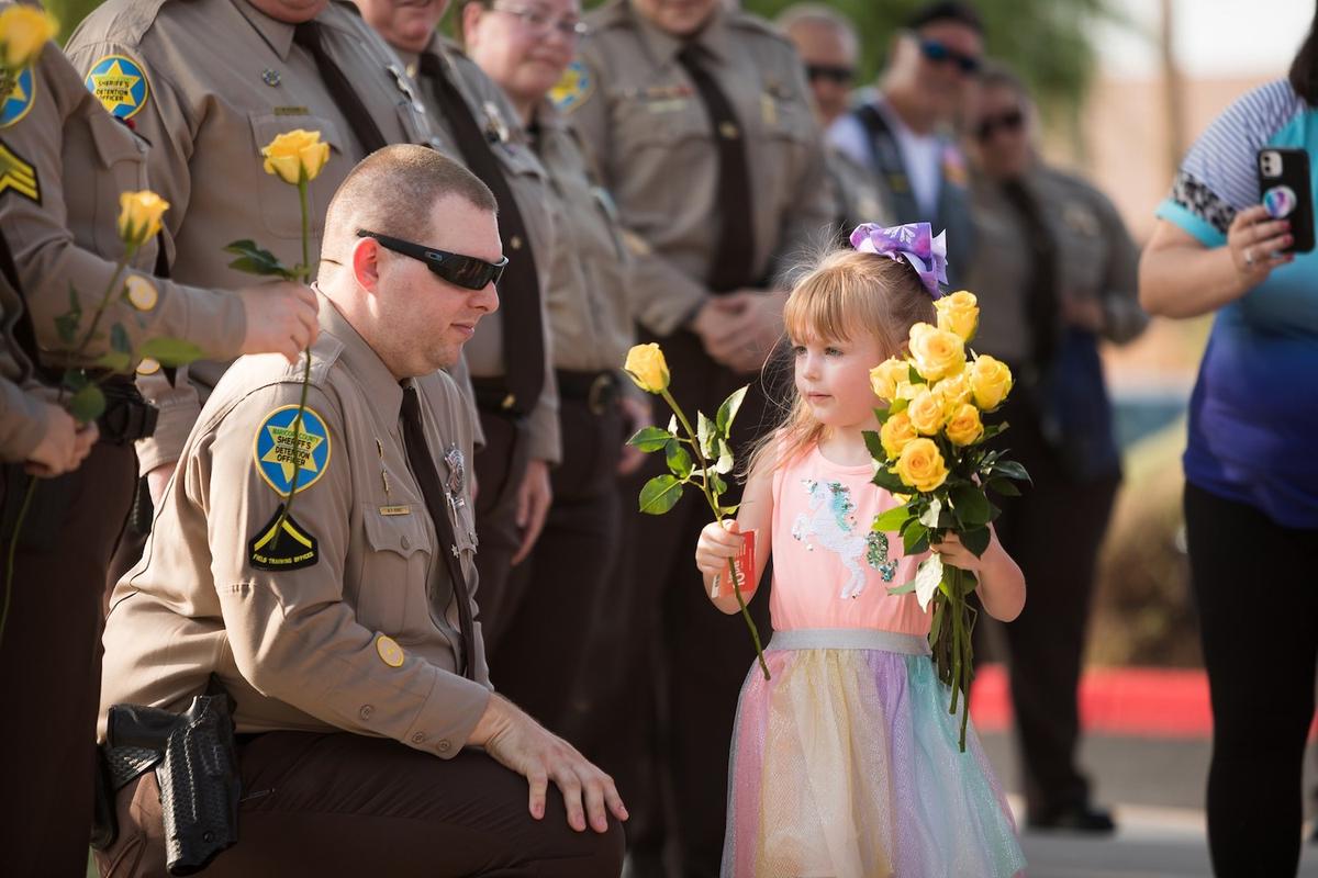 Julianna Kinnard receives flowers from Maricopa County Sheriff's Office deputies outside Conley Elementary School. (Courtesy of <a href="https://www.facebook.com/JoshuaKinnardFoundation">Maggie Jones</a>)