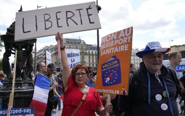 A protestor holds a sign that reads "Freedom" in French, and "No to the health passport" as she attends a demonstration in Paris on July 31, 2021. (Michel Euler/AP Photo)