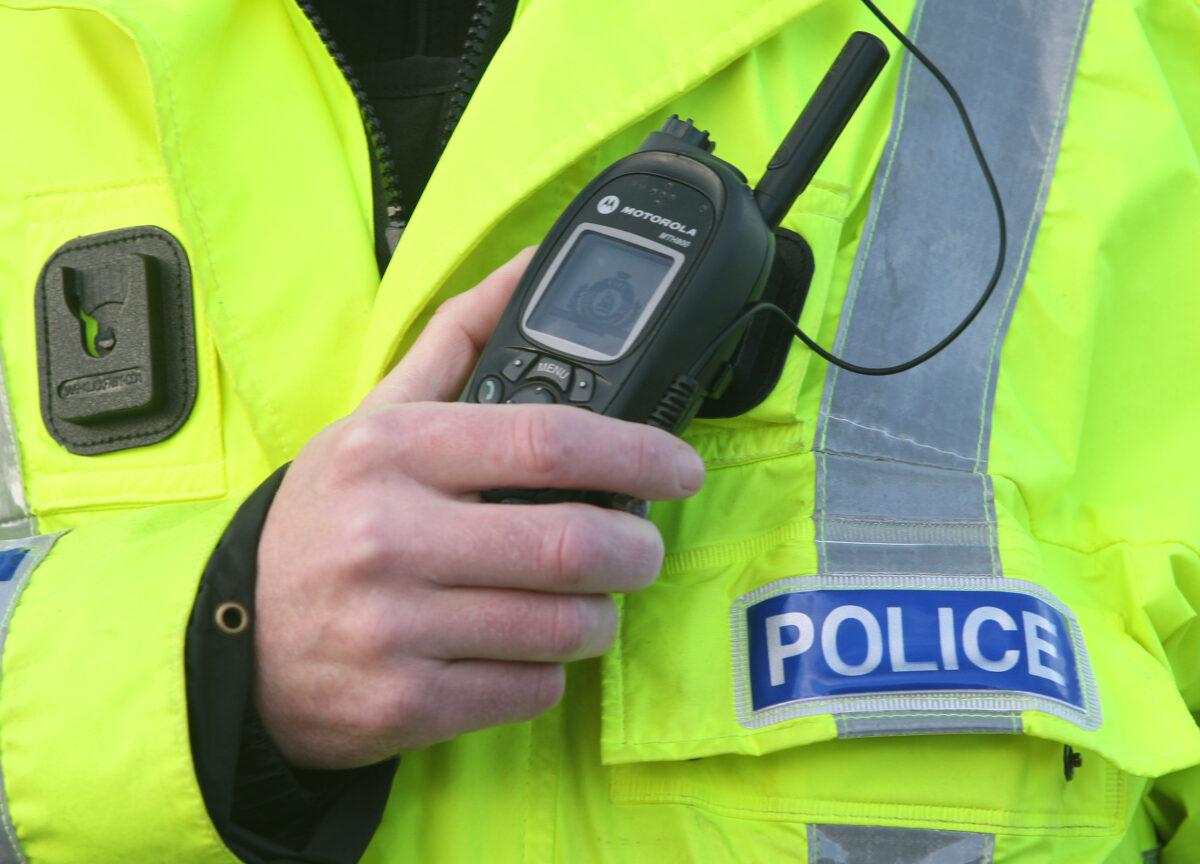 A police officer using a radio in the UK on Nov. 2, 2011. (David Cheskin/PA Media)