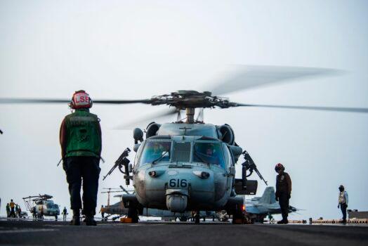 In this photo provided by the U.S. Navy, sailors on board an MH-60S Seahawk helicopter on the flight deck of the aircraft carrier USS Ronald Reagan prepare to head to an oil tanker that was attacked off the coast of Oman in the Arabian Sea on Friday, July 30, 2021. (Mass Communication Specialist 2nd Class Quinton A. Lee/U.S. Navy, via AP)