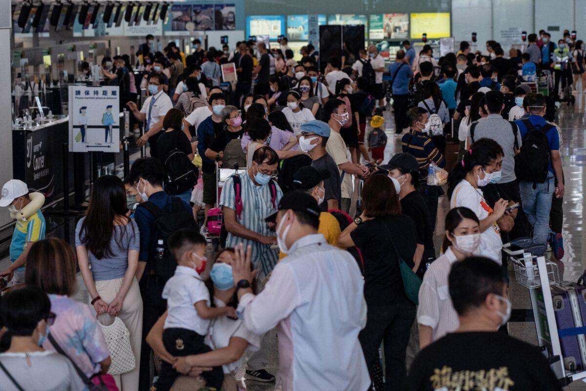 People pack the check-in area for their flight to Britain at Hong Kong's International Airport on July 18, 2021. (BERTHA WANG/AFP via Getty Images)