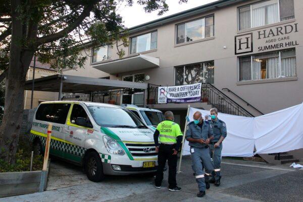 An ambulance officer and staff are seen at the entrance of the Hardi Aged Care Nursing Home Facility at Summer Hill in Sydney, Australia, on Aug. 2, 2021. (Lisa Maree Williams/Getty Images)