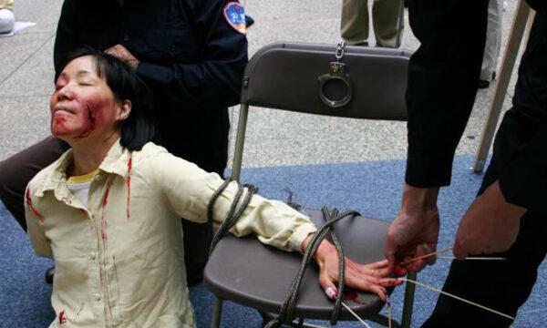 Reenactment of one of the torture methods employed by Chinese officials to coerce Falun Gong practitioners to renounce their faith.<br/>(Minghui.org)