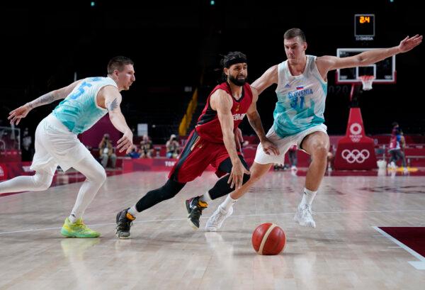 Germany's Joshiko Saibou (1) (C) and Slovenia's Vlatko Cancar (31) (R) chase the loose ball during men's basketball quarterfinal game at the 2020 Summer Olympics, in Saitama, Japan, on Aug. 3, 2021. (Charlie Neibergall/AP Photo)