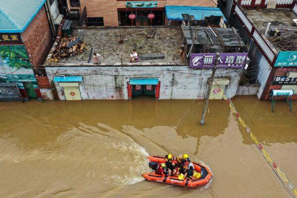 Rescue workers evacuating residents following heavy rains in Xinxiang, in China's central Henan province, on July 23, 2021. (AFP via Getty Images)