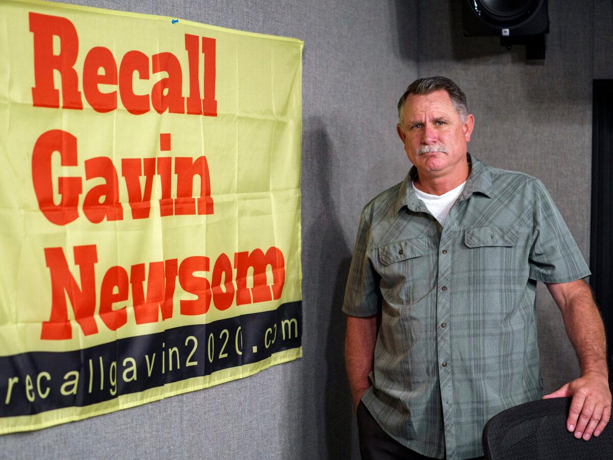 Orrin Heatlie, the main organizer for the campaign to recall California Gov. Gavin Newsom, poses with a banner at KABC radio station studio in Culver City, Calif., on March 27, 2021. (Damian Dovarganes/AP Photo)