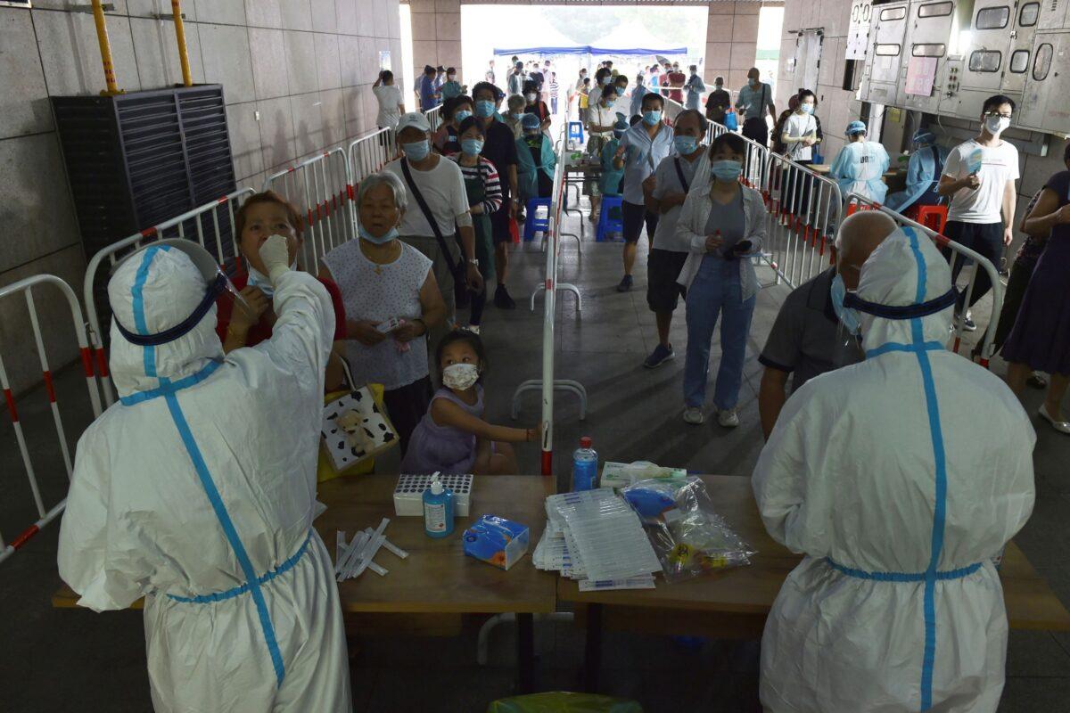 Medical workers take throat swab samples in the new round of COVID-19 testing in Nanjing, Jiangsu Province, China, on Aug. 2, 2021. (Chinatopix via AP)