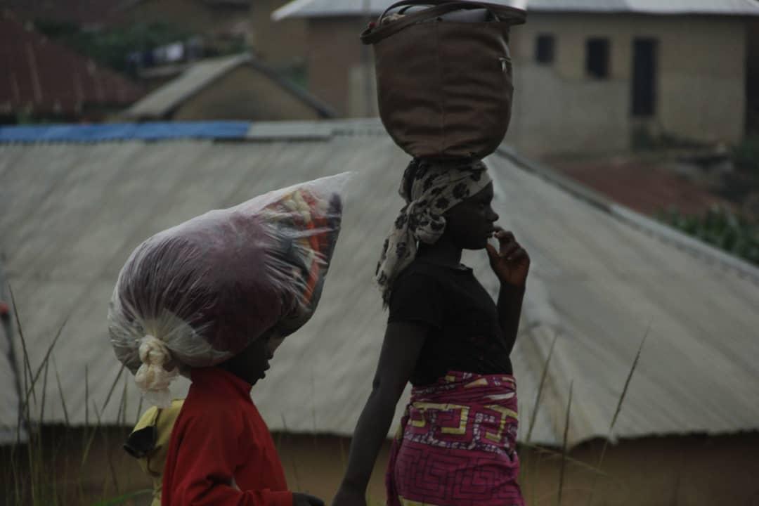 Women carrying their belongings flee their homes in Plateau state, Nigeria, on Aug. 3, 2021. (Masara Kim/The Epoch Times)