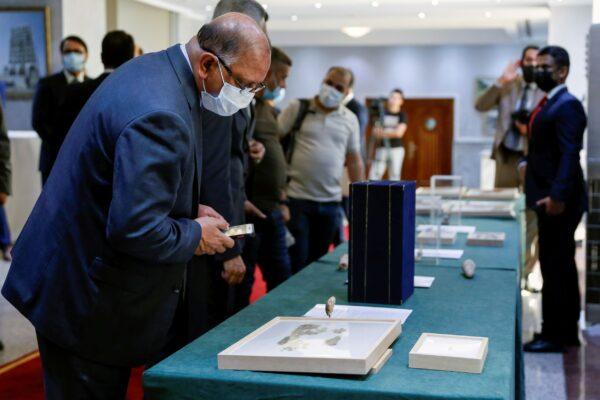 Officials look at artifacts seized by the U.S. government and returned to Iraq, which are on display at the Ministry of Foreign Affairs in Baghdad, Iraq, on Aug. 3, 2021. (Saba Kareem/Reuters)