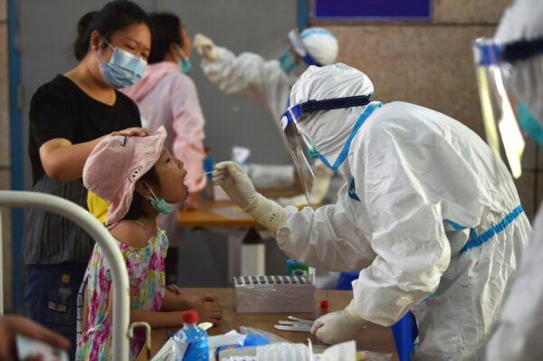 A nurse takes throat swab samples in the new rounds of COVID-19 test in Nanjing in China's Jiangsu Province, on Aug. 2, 2021. (Chinatopix/Via AP)
