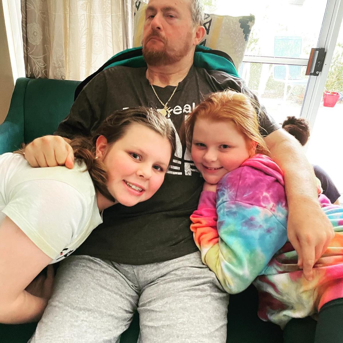 Paul with his two daughters in May 2021. (Courtesy of <a href="https://www.facebook.com/thecarefactor.tbi/">The Care Factor</a>)