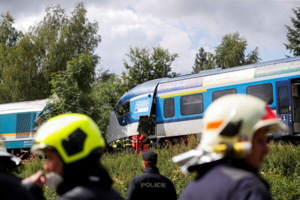 A police officer and firefighters work on a site of a train crash near the town of Domazlice, Czech Republic, on Aug. 4, 2021. (David W Cerny/Reuters)
