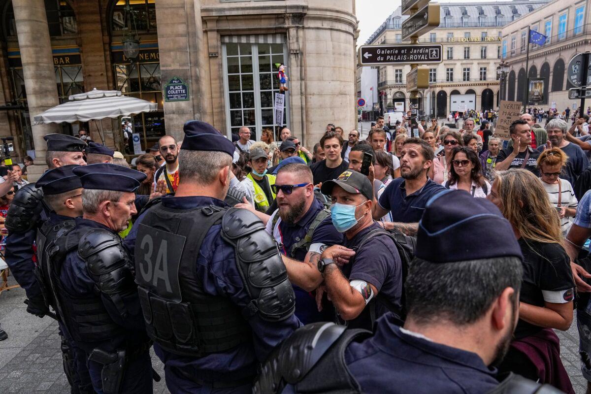 Anti heath pass demonstrators face police officers outside the Constitutional Council in Paris, on Aug. 5, 2021. (Michel Euler/AP Photo)