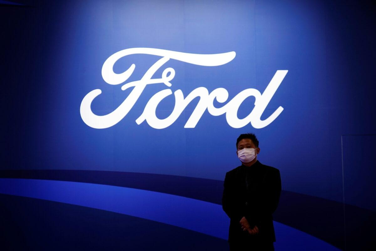 A man stands near the Ford logo during a media day for the Auto Shanghai show in Shanghai, China, on April 19, 2021. (Aly Song/Reuters)