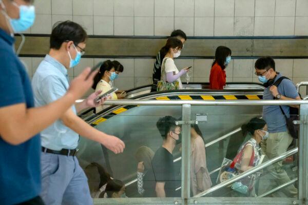 People wearing masks walk through a subway station during the morning rush hour in Beijing, China, on Aug. 4, 2021. (Mark Schiefelbein/AP Photo)