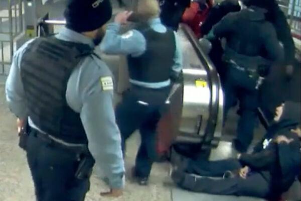 In this Feb. 28, 2020, image from Chicago Transit Authority video provided by the Civilian Office of Police Accountability, police officers attend to Ariel Roman, bottom right, after he was shot by Chicago police in a subway station in Chicago. Chicago Police officer Melvina Bogard, who shot Roman, an unarmed man, in the back as he tried to escape capture by running up an escalator last year has been charged with felony aggravated battery with a firearm and official misconduct, prosecutors said Thursday, Aug. 5, 2021.  (Chicago Transit Authority via AP File)