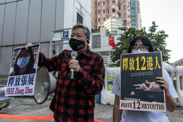 A pro-democracy activist (L) holds a placard with the picture of former lawyer Zhang Zhan outside the Chinese central government's liaison office in Hong Kong, on Dec. 28, 2020. (Anthony Kwan/Getty Images)
