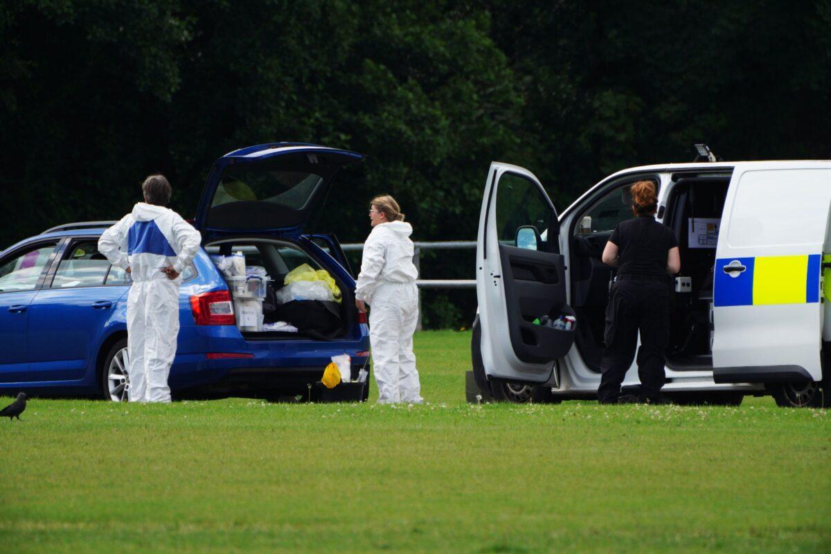 Police forensic officers at the scene in the Sarn area of Bridgend, south Wales, near to where 5-year-old Logan Mwangi was found dead in the Ogmore River, in Wales, Britain, on Aug. 3, 2021. (Ben Birchall/PA)