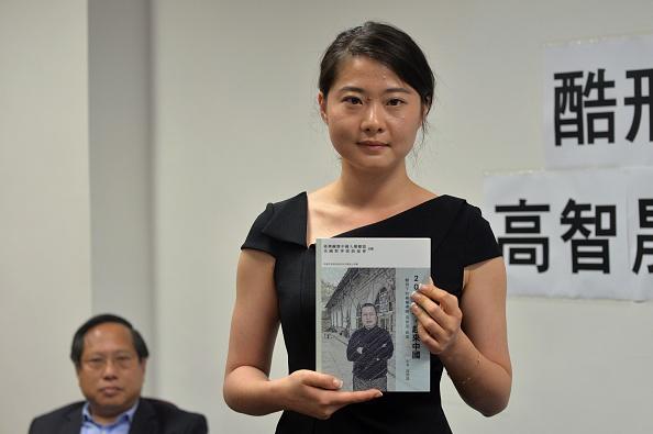 Grace Geng (R), daughter of Gao Zhisheng, a renowned human rights lawyer in China, holds her father's book "A Human Rights Lawyer under Torture the auto narratives of Gao Zhisheng," as lawmaker Albert Ho (L) looks on during a press conference at the Legislative Council Complex in Hong Kong on June 14, 2016. (Anthony Wallace/AFP via Getty Images)