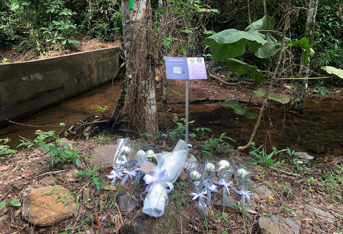 Below a sign marking indigenous species of trees, flowers are placed at the scene where a woman was found dead a day earlier at a secluded spot on the southern island of Phuket, Thailand, on Aug. 6, 2021. (AP Photo)