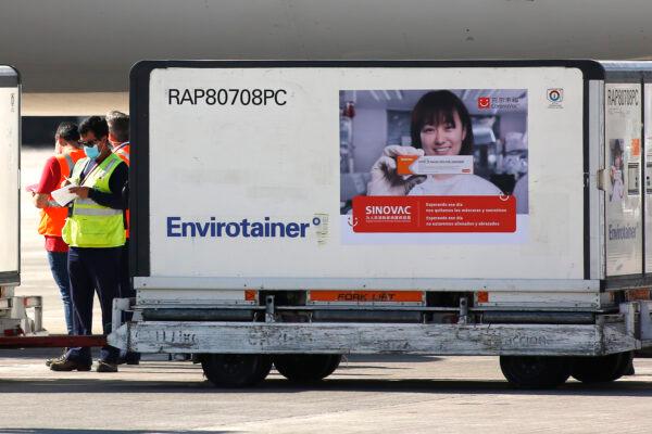 An airport worker stands guard next to a vaccine container during the arrival of two million Sinovac doses at Arturo Merino Benitez International Airport in Santiago, Chile, on Feb. 25, 2021. (Marcelo Hernandez/Getty Images)