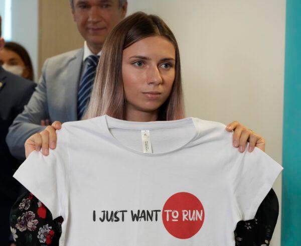 Belarusian Olympic sprinter Krystsina Tsimanouskaya, who came to Poland Wednesday fearing reprisals at home after criticizing her coaches at the Tokyo Games, is showing an Olympic-related T-shirt with her slogan "I Just Want to Run" after her news conference in Warsaw, Poland, on Aug. 5, 2021. (Czarek Sokolowski/AP Photo)