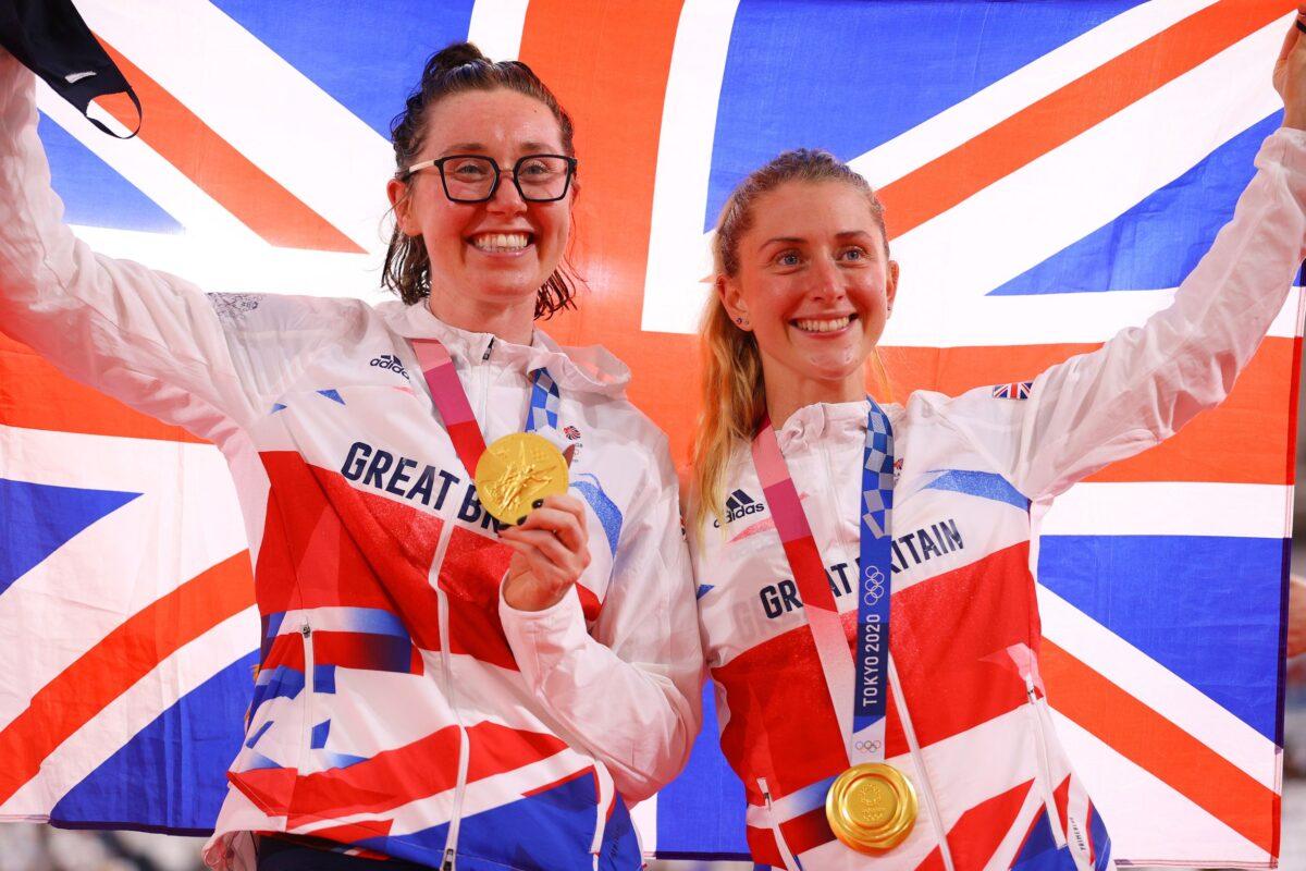Gold medalists Katie Archibald and Laura Kenny of Team Great Britain, pose on the podium while holding the flag of their country during the medal ceremony after the Women's Madison final of the track cycling on day fourteen of the Tokyo 2020 Olympic Games at Izu Velodrome in Izu, Japan, on Aug. 6, 2021. (Tim de Waele/Getty Images)