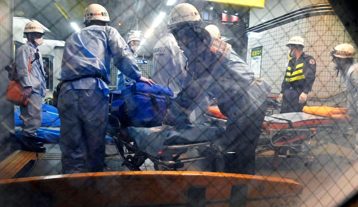 Rescuers prepare stretchers at Soshigaya Okura Station after stabbing on a commuter train, in Tokyo, Japan, on Aug. 6, 2021. (Kyodo News via AP)