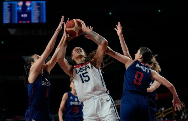 United States' Brittney Griner (15) drives between Serbia's Sonja Vasic (5), left, and Jelena Brooks (9), right, during women's basketball semifinal game at the 2020 Summer Olympics, in Saitama, Japan, on Aug. 6, 2021. (Eric Gay/AP Photo)