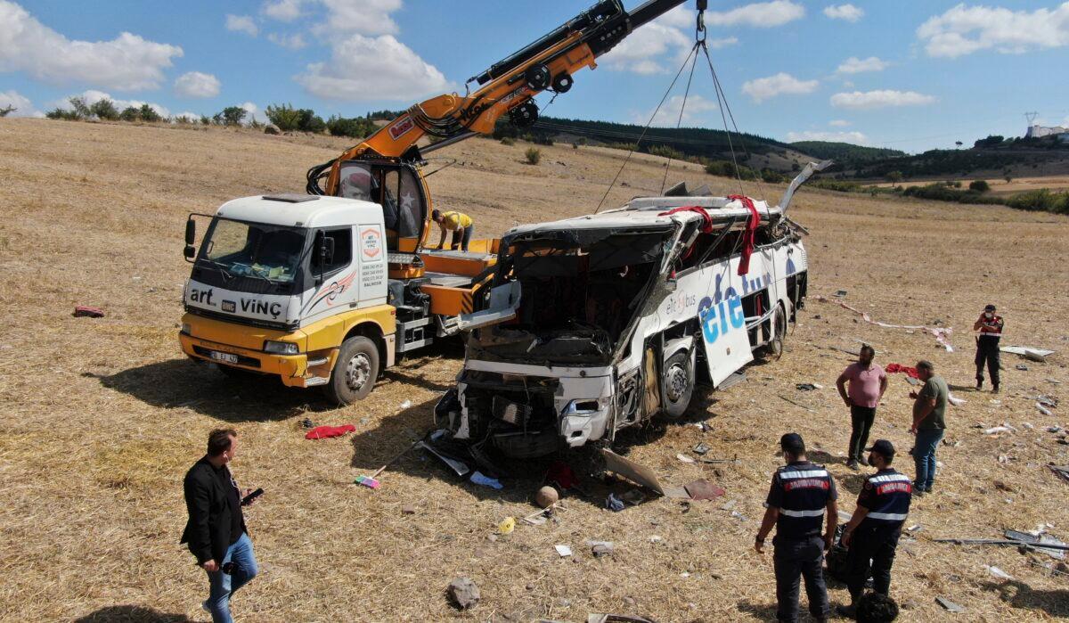 Officials investigate at the site of a bus crash, in Balikesir, western Turkey, on Aug. 8, 2021. (IHA via AP)