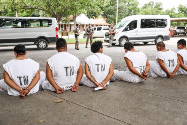 Illegal immigrants wait to be magistrated on trespassing charges in Kinney County outside the Sheriff's Office in Brackettville, Texas, on Aug. 6, 2021. (Charlotte Cuthbertson/The Epoch Times)