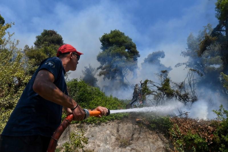 A firefighter tries to extinguish a wildfire burning near the village of Vasilika, on the island of Evia, Greece, on Aug. 8, 2021. (Alexandros Avramidis/Reuters)