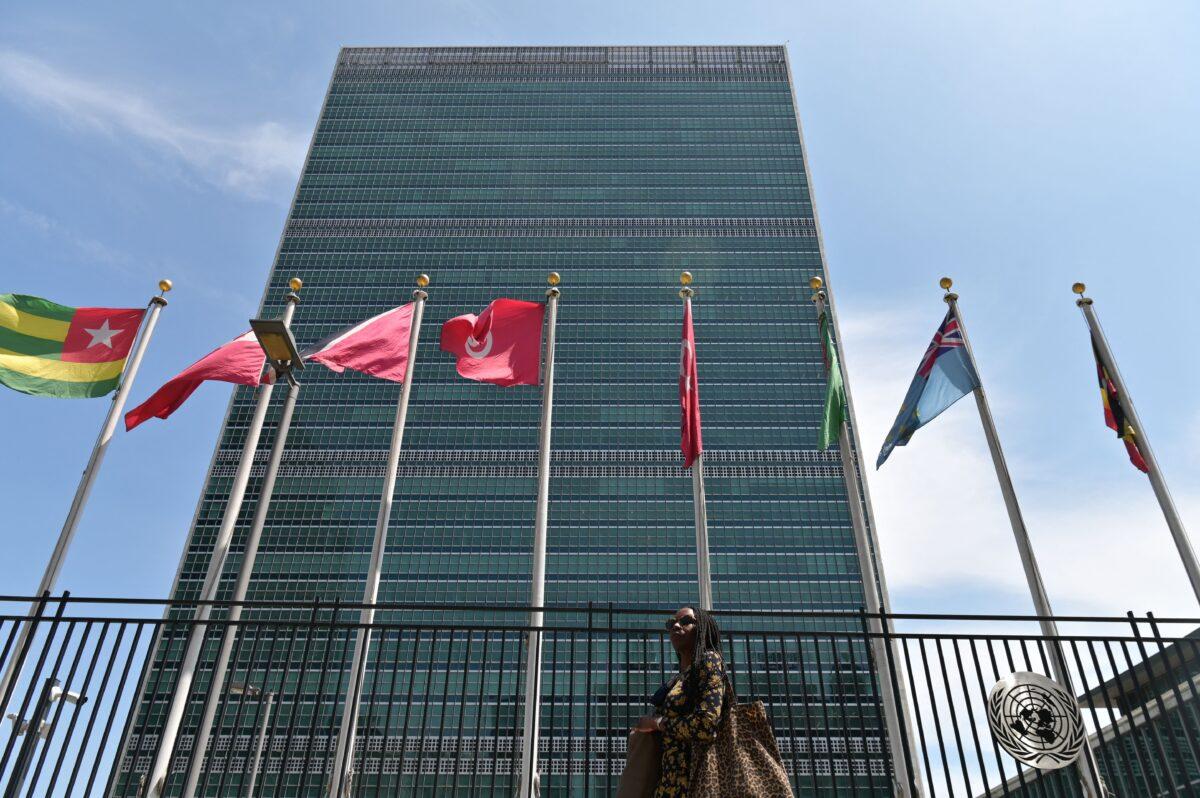 A person walks past flags outside the United Nations headquarters in New York City on May 20, 2021. (Angela Weiss/AFP via Getty Images)