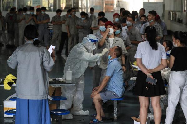 A worker receives a COVID-19 test at the dining hall of a car parts factory in Wuhan, central China's Hubei Province on Aug. 4, 2021. (STR/AFP via Getty Images)