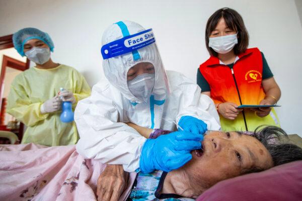 A medical worker is taking a swab sample for the COVID-19 test from an elderly resident at her home in Nantong, China, on Aug. 8, 2021. (STR/AFP via Getty Images)