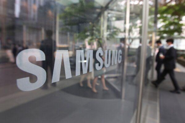Employees walk past a logo of the Samsung Electronics Co. at its office in Seoul, South Korea, on April 28, 2021. (Ahn Young-joon, File/AP Photo)