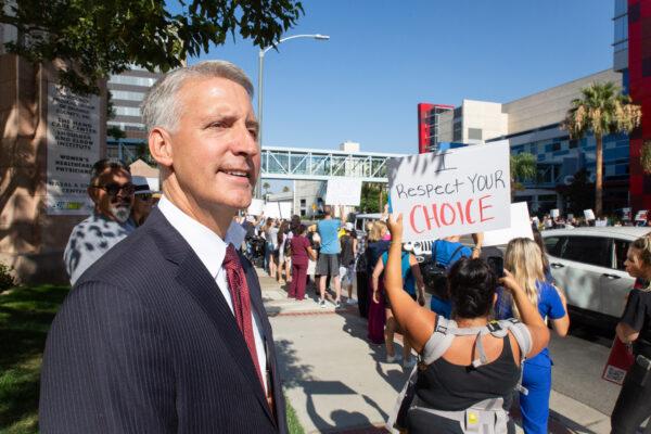 Brad W. Dacus, president of the Pacific Justice Institute, joins medical personnel to protest mandatory vaccines in Orange, Calif., on Aug. 9, 2021. (John Fredricks/The Epoch Times)