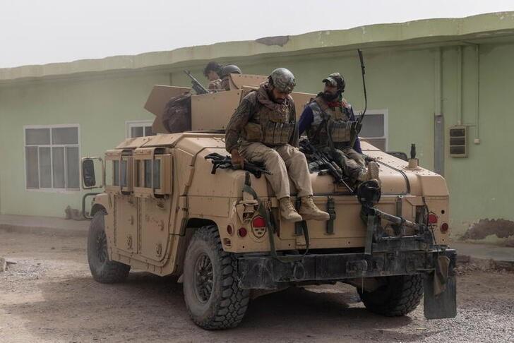 Members of Afghan Special Forces climb down from a humvee as they arrive at their base after heavy clashes with the Taliban during the rescue mission of a police officer besieged at a check post, in Kandahar province, Afghanistan, on July 13, 2021. (Danish Siddiqui/Reuters)