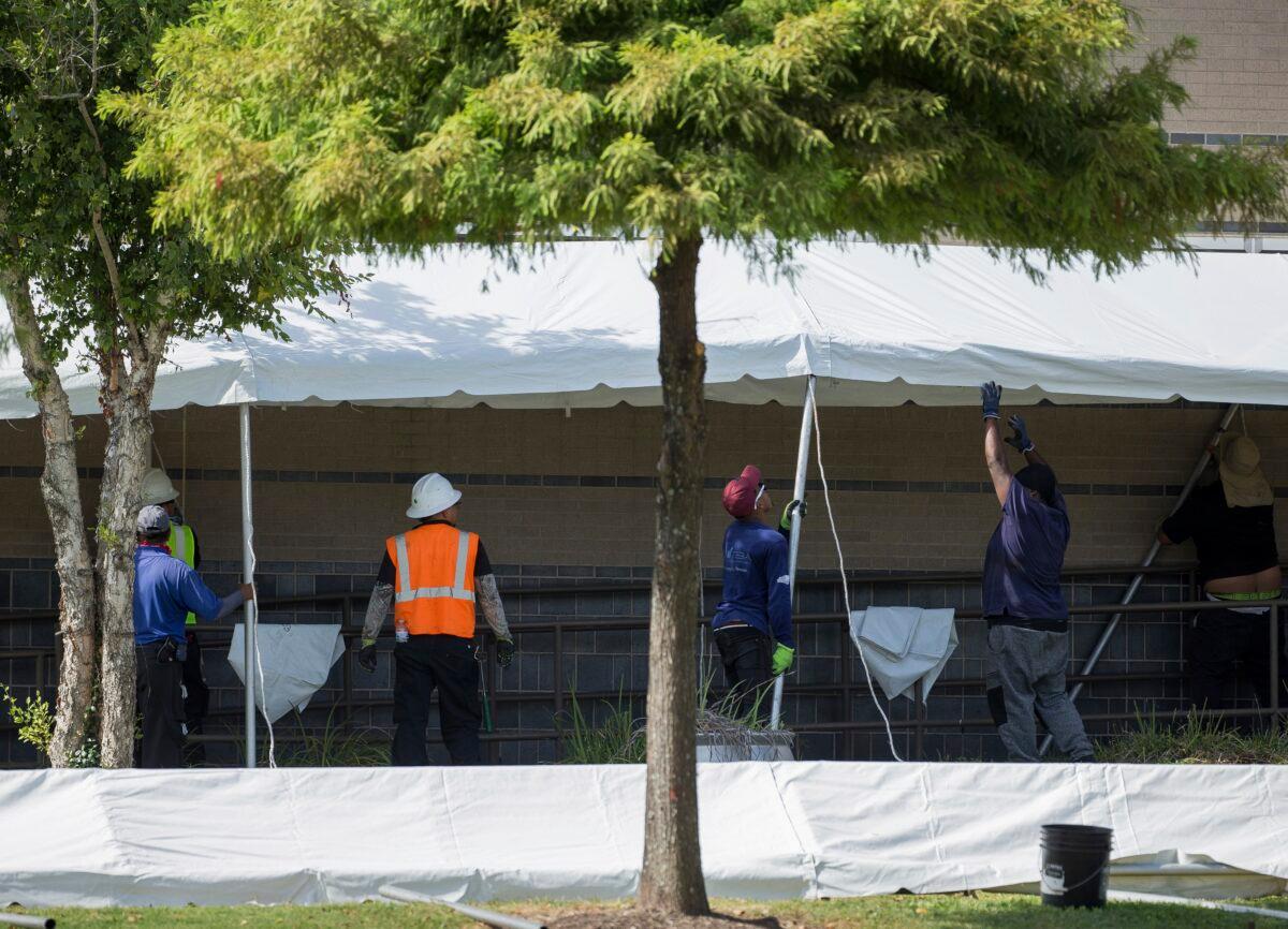 A construction crew works to set up tents that hospital officials plan to use with an overflow of COVID-19 patients outside of Lyndon B. Johnson Hospital in Houston, Texas, on Aug. 9, 2021. (Godofredo A. Vásquez/Houston Chronicle via AP)
