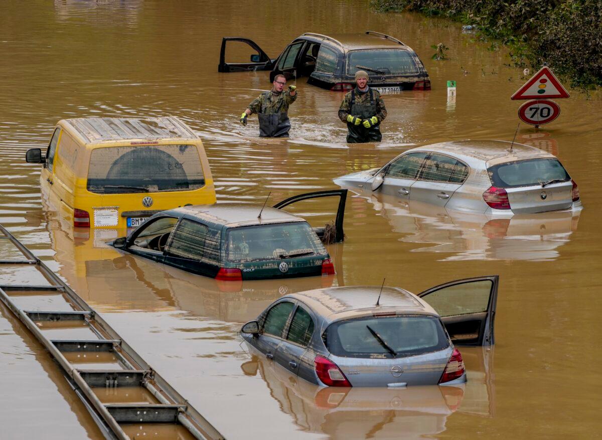 People check for victims in flooded cars on a road in Erftstadt, Germany, on July 17, 2021. (Michael Probst/AP Photo)