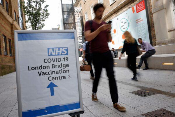 People pass signs indicating the entrance to the London Bridge Vaccination Centre in London on Aug. 9, 2021. (Tolga Akmen/AFP via Getty Images)