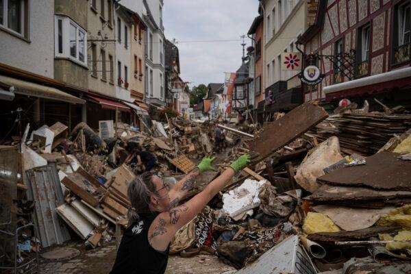 A woman throws away flood damaged rubbish in the center of Bad Neuenahr-Ahrweiler, Germany, on July 19, 2021. (Bram Janssen/AP Photo)