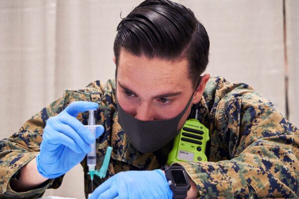 U.S. Navy Hospital Corpsman 2nd Class Orbie VanCurine, a native of Mansfield, Texas, with Combat Logistics Battalion 22 (CLB-22), prepares a COVID-19 vaccine during the opening of the state-run, federally-supported Center City Community Vaccination Center at the Pennsylvania Convention Center in Philadelphia on March 3, 2021. (U.S. Marine Corps photo by 1st Lt. Kevin Stapleton / Combat Logistics Battalion 22)