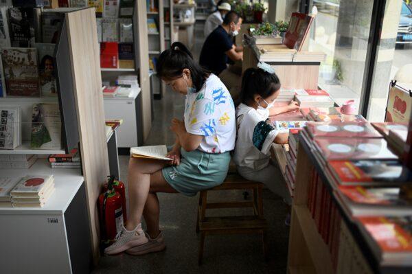A woman and a child read books at a bookstore in Beijing, on July 14, 2021. (Wang Zhao/AFP via Getty Images)