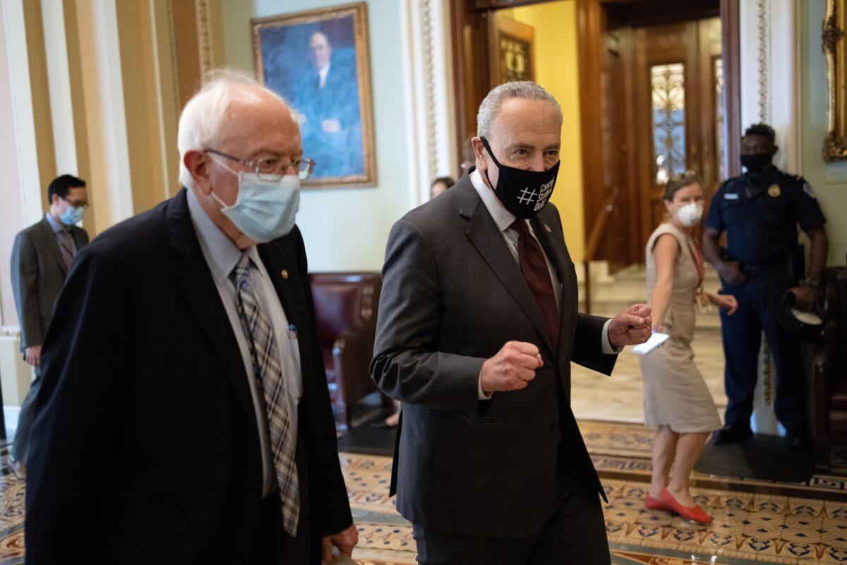 Sen. Bernie Sanders (I-Vt.) (L) walks with Senate Majority Leader Chuck Schumer (D-N.Y.) after meeting on a $3.5 trillion budget that was rammed through by Senate Democrats early Aug. 11, 2021, in Washington on Aug. 9, 2021. (Win McNamee/Getty Images)
