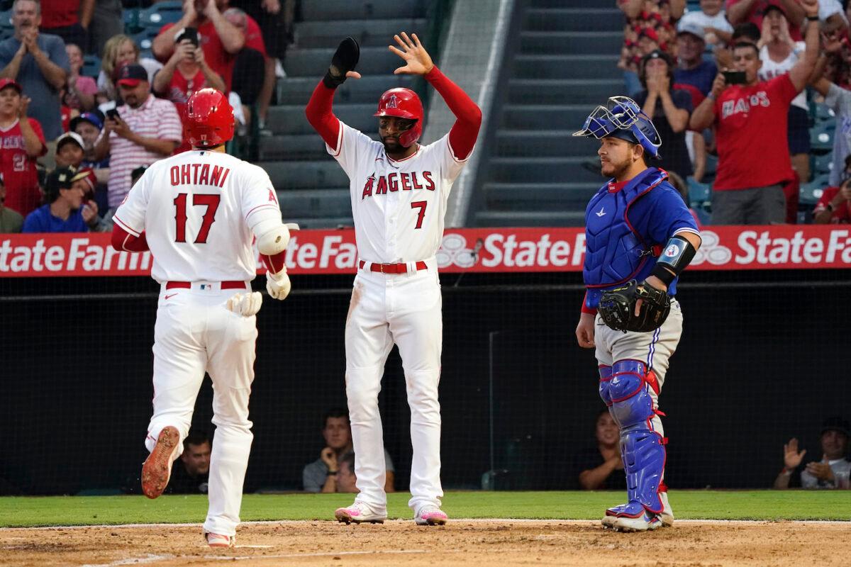 Los Angeles Angels' Shohei Ohtani is met at home plate by Jo Adell (7) after Ohtani's two-run home run during the third inning of the team's baseball game against the Toronto Blue Jays in Anaheim, Calif., on Aug. 11, 2021. (AP Photo/Marcio Jose Sanchez)