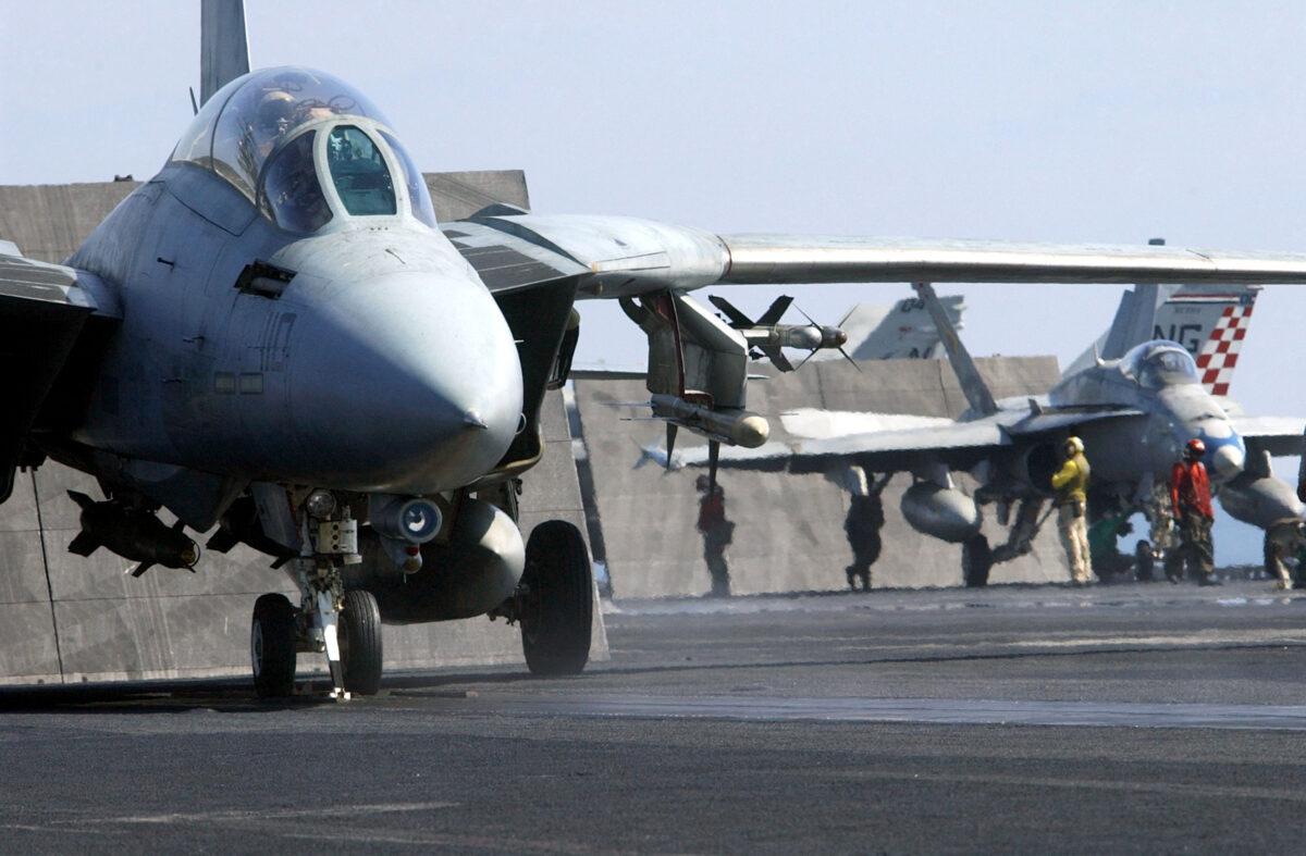 An F-14A Tomcat fighter (L) and an F/A-18 Hornet strike fighter (R) prepare to launch at sea aboard the USS John C. Stennis on Feb. 25, 2002. The Stennis and Carrier Air Wing Nine (CVW-9) were conducting combat missions over Afghanistan in support of Operation Enduring Freedom. (Jayme Pastoric/U.S. Navy/Getty Images)